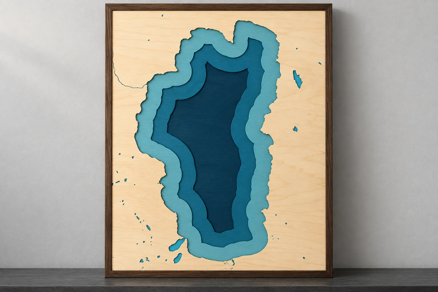 Simulated Lake Tahoe layered wood map with blue water and a dark walnut border on a studio shelf